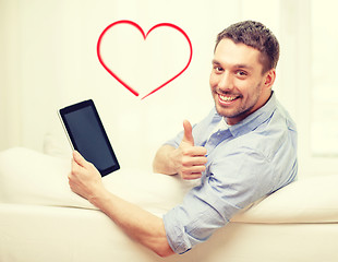 Image showing smiling man working with tablet pc at home