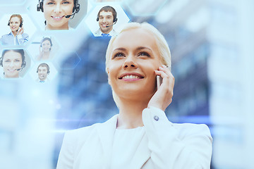 Image showing smiling businesswoman with smartphone outdoors