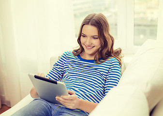 Image showing smiling teenage girl with tablet pc at home