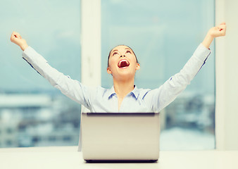 Image showing screaming businesswoman with laptop in office