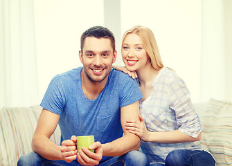 Image showing smiling man with cup of tea or coffee with wife