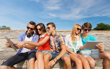 Image showing group of smiling friends with tablet pc outdoors