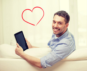 Image showing smiling man working with tablet pc at home