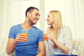 Image showing smiling happy couple at home drinking juice