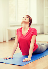 Image showing smiling teenage girl streching at home