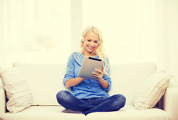 Image showing woman with tablet pc and headphones at home