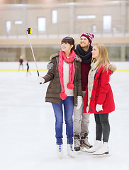 Image showing happy friends with smartphone on skating rink