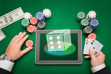 Image showing casino poker player with cards, tablet and chips