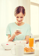 Image showing smiling young woman with smartphone reading news