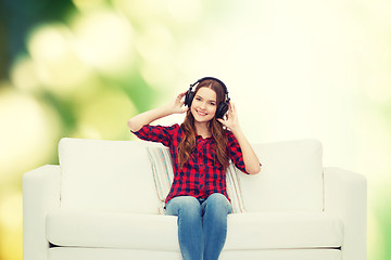 Image showing teenage girl sitting on sofa with headphones