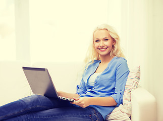 Image showing smiling woman with laptop computer at home