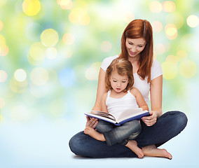 Image showing happy mother with adorable little girl and book