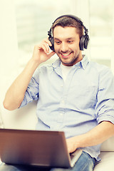 Image showing smiling man with laptop and headphones at home