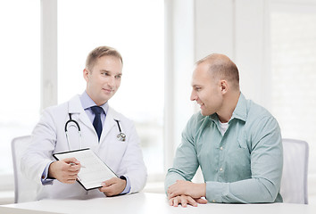 Image showing doctor with clipboard and patient in hospital