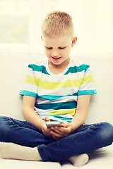 Image showing smiling little boy with smartphone at home