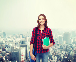 Image showing smiling female student with bag and notebooks