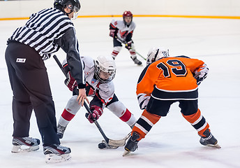 Image showing Puck playing between players of ice-hockey teams