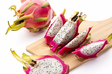 Image showing Four Fruit Wedges Of A Cut Pitaya On Cutting Board