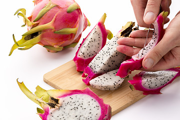 Image showing Hands Removing Pulp From A Pitaya Fruit Wedge