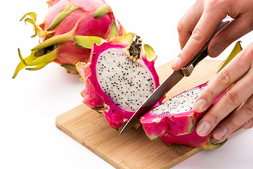 Image showing Hands Of A Chef Cutting A Dragonfruit In Half