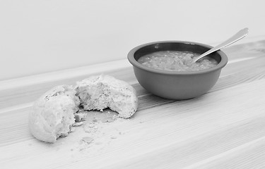 Image showing Soup served with a torn crusty bread roll