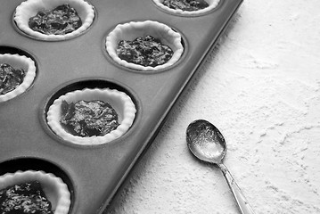 Image showing Filled, uncooked jam tarts in a tin