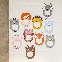 Image showing Set of cardboard masks on a white brick wall.