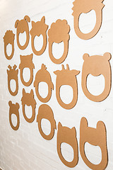 Image showing Set of cardboard masks on a white brick wall.