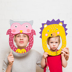 Image showing Little girls and mother holding lion mask on white background