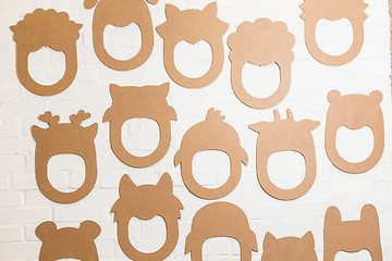 Image showing Set of cardboard masks on a white brick wall.