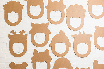 Image showing Set of cardboard masks on a white brick wall.