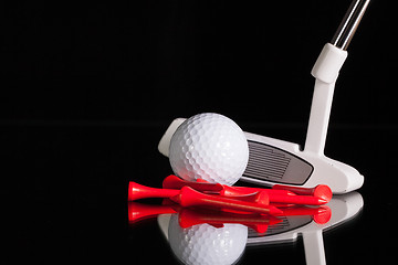 Image showing Golf putter and gold equipments on the black glass desk