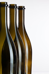 Image showing Empty bottles of wine on a glass desk