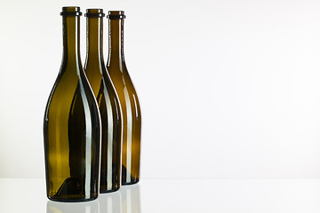 Image showing Empty bottles of wine on a glass desk