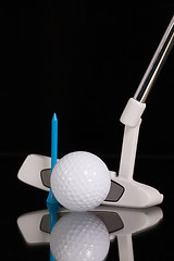 Image showing Golf putter and gold equipments on the black glass desk