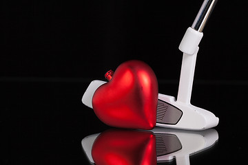 Image showing Golf putter and love symbol on the black glass desk