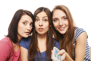 Image showing Three surprised women with TV remote control