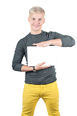 Image showing Smiling young casual man holding white sign 