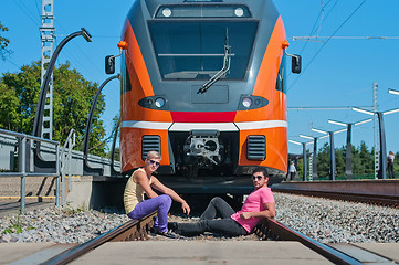 Image showing Young trendy guys in front of train