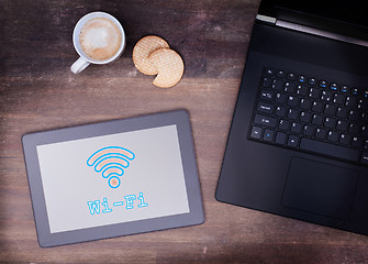 Image showing Tablet with Wi-Fi connection on a wooden desk