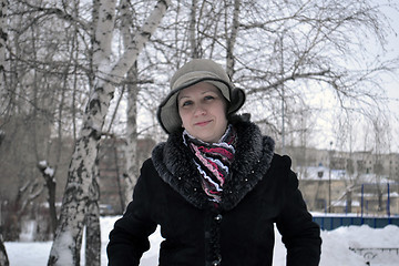 Image showing The woman in a hat and a sheepskin coat costs in park in the win