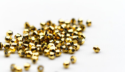 Image showing Beautiful golden glass beads closeup on white background