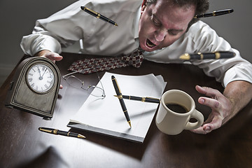 Image showing Stressed Man At Desk, Pens, Coffee, Glasses, Clock Flying Up