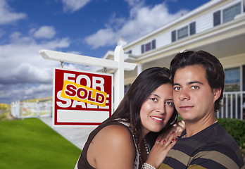 Image showing Hispanic Couple, New Home and Sold Real Estate Sign