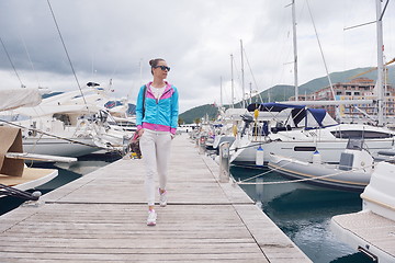 Image showing relaxed young woman walking in marina