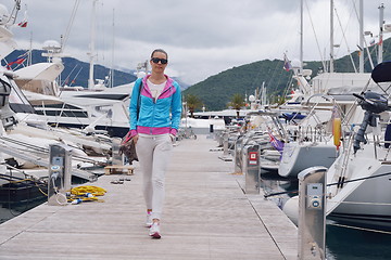 Image showing relaxed young woman walking in marina