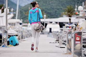 Image showing relaxed young woman walking in marina