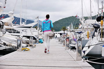 Image showing relaxed young woman walking in marina