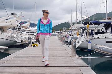 Image showing relaxed young woman walking in marina