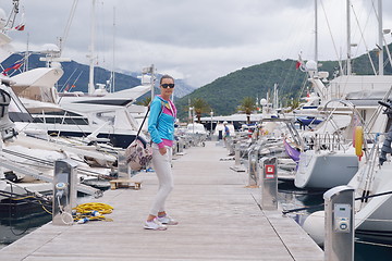 Image showing relaxed young woman walking in marina